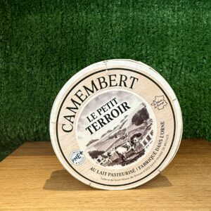 A picture of a boxed Camembert Le Petit Terroir. It is on a wooden board with a green background