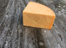 A picture showing a wedge of Appleby's Cheshire Cheese positioned on a rustic looking wooden table