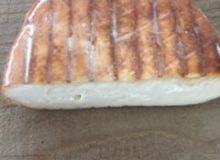 A picture of half a wheel of Brun de Noix Cheese. It has been placed on a wooden table