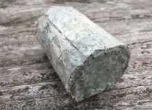 A picture showing a Driftwood cheese positioned on a rustic, wooden table