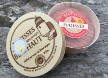 A picture showing an Époisses PDO in its wooden box. It is sat on a wooden table