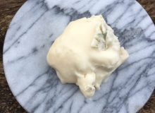 A picture showing a scoop of Gorgonzola Dolce PDO. It almost looks like a scoop of melting ice cream!