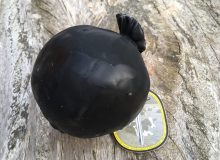 A photo depicting a Lancashire Bomb Cheese. The cheese is positioned on a rustic looking wooden table.