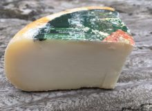 A picture of a wedge of Pecorino Dolce. It has been placed on a rustic wooden table