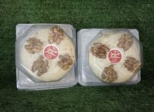 A picture of 2 St Julien cheeses, showing the walnuts on the top